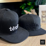 A cap with a straight brim TĒTIS.