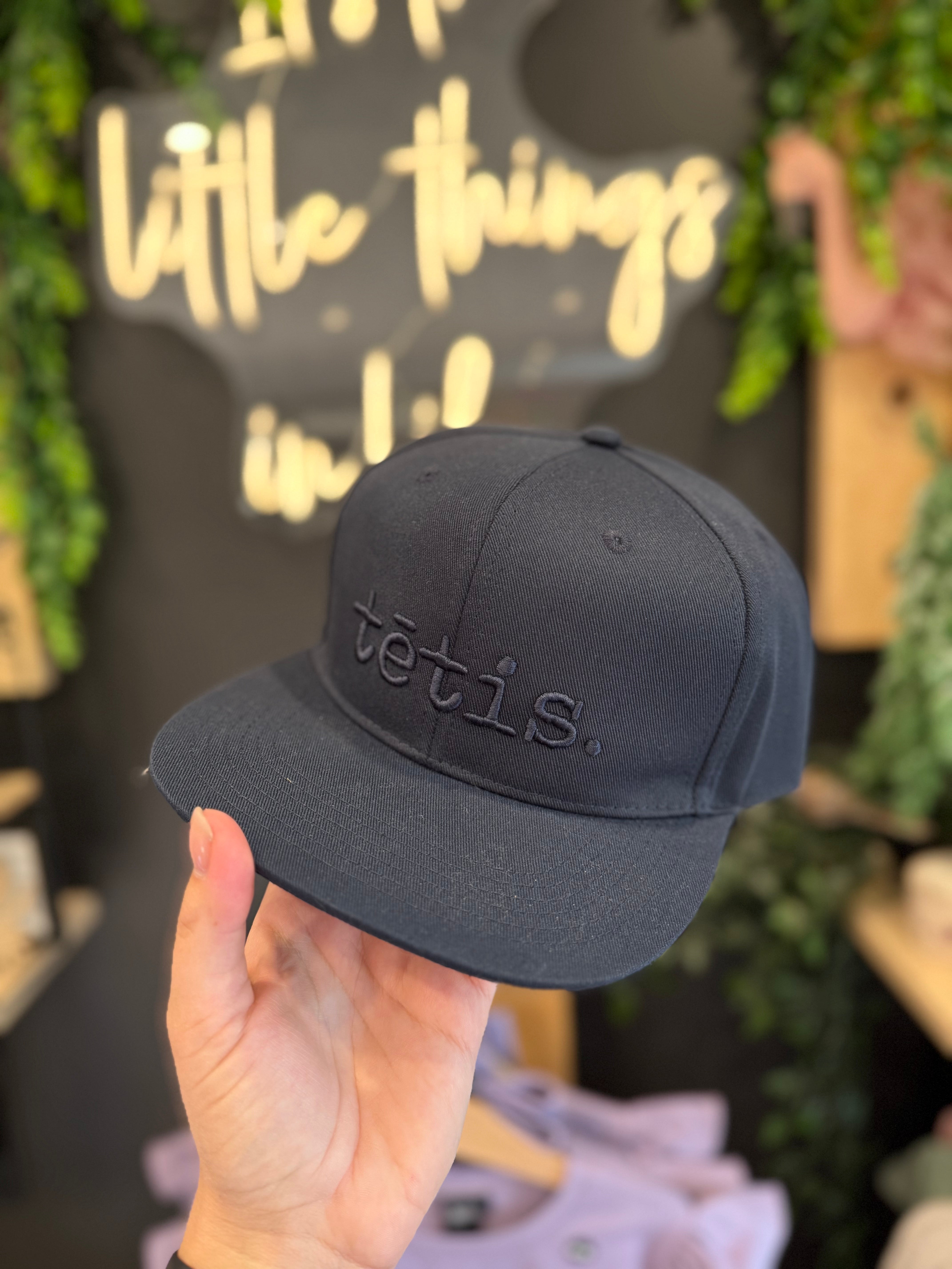 A cap with a straight brim TĒTIS.